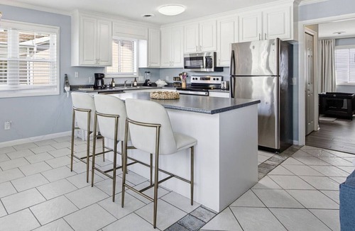 Wrightsville Beach Apartment | Coastal 4BR/4BA coastal duplex featuring king and queen ensuite bedrooms, a fully stocked kitchen, fenced pet-friendly yard, outdoor shower, beach gear, Smart TVs, WiFi, and parking for up to 6+ vehicles.