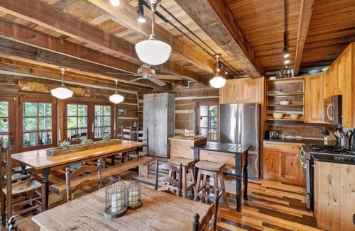 Guntersville Cabin | Historic lakefront log cabin on Lake Guntersville, restored from two pre-Civil War cabins. Sleeps 20 with 4BR/5BA, loft bunks, designer finishes, modern comforts, and steps to swimming, fishing & boating.