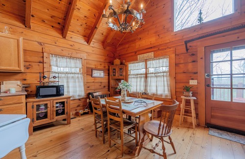 Floyd House | Peaceful log cabin retreat with wraparound deck, open living space, full kitchen, cozy bedrooms & scenic wooded views.
