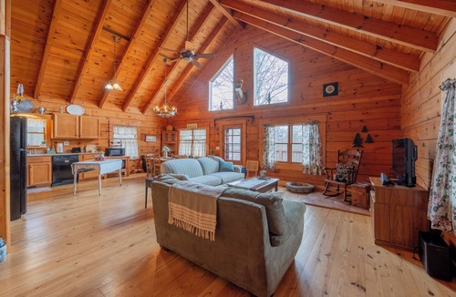 Floyd House | Peaceful log cabin retreat with wraparound deck, open living space, full kitchen, cozy bedrooms & scenic wooded views.