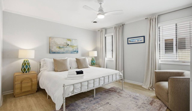 Coastal 4BR/4BA coastal duplex featuring king and queen ensuite bedrooms, a fully stocked kitchen, fenced pet-friendly yard, outdoor shower, beach gear, Smart TVs, WiFi, and parking for up to 6+ vehicles.