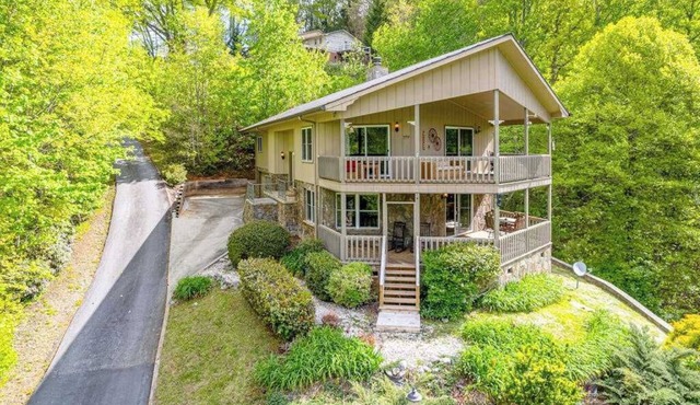 View-worthy home lined by trees with a fireplace, wrap-around deck, grill, & W/D